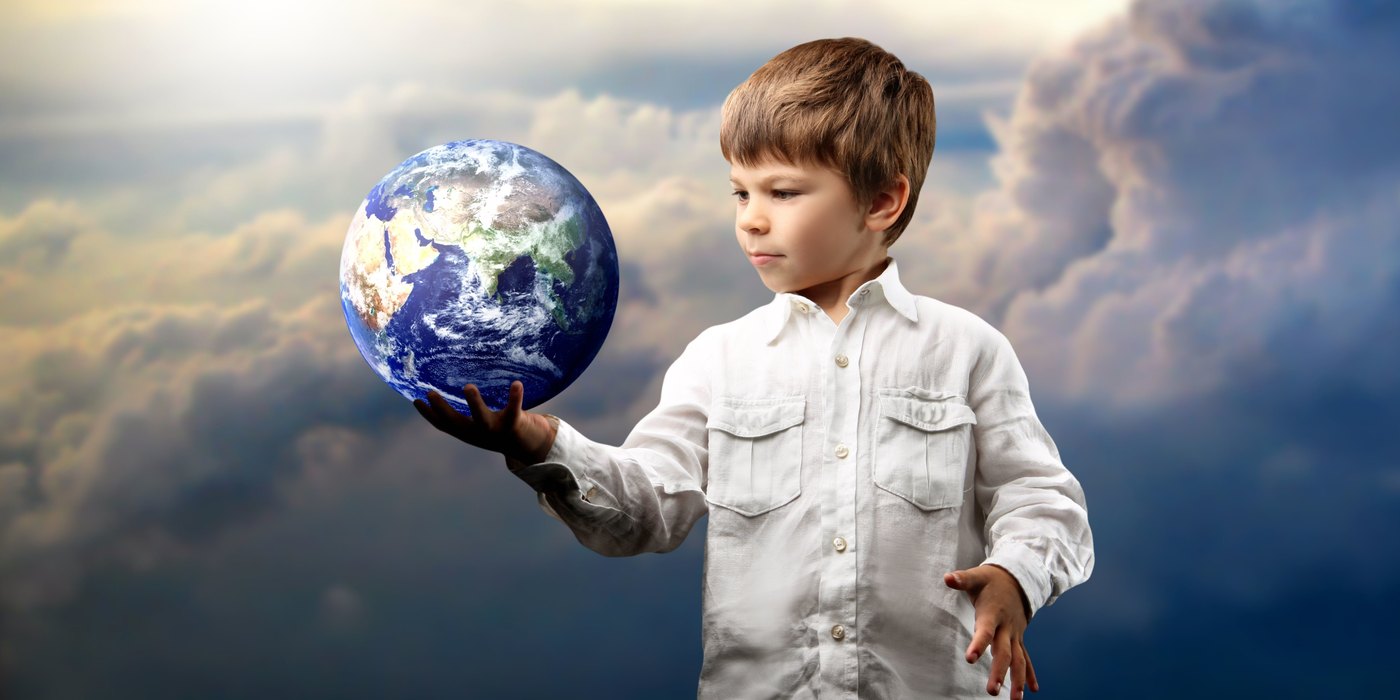 A young boy holding the Earth in his open hand